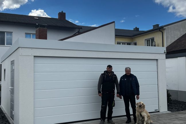 spokojený zákazník s pejskem před bílou garáží