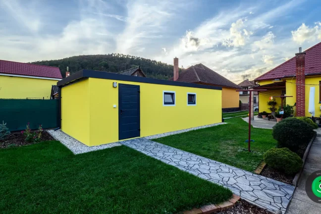 boční dveře garáže se žlutou omítkou