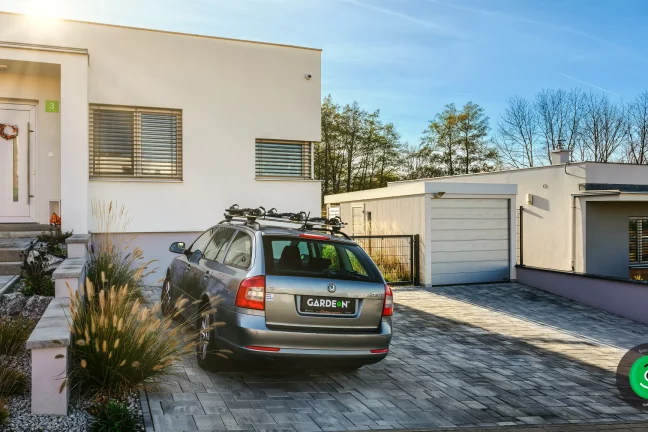 velký bílý dům s garáží pro jedno auto