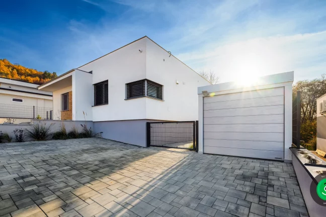 bílá malá garáž vedle rodinného domu