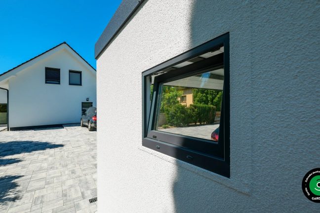 Dvě boční okna na velké montované garáži.