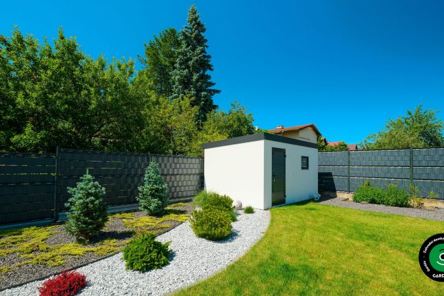 Domeček v bílé barvě v zahradě.