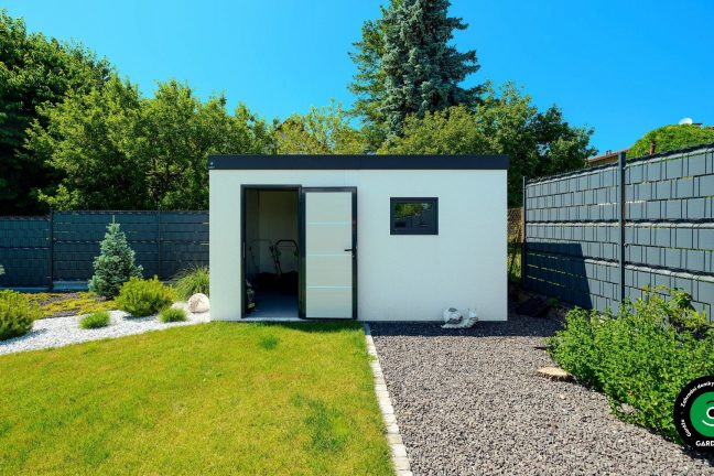 Kompaktní bílý domek uprostřed rozkvetlé zahrady.