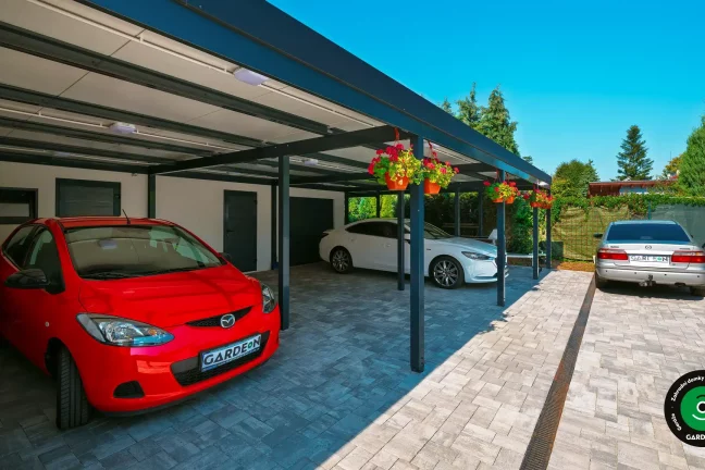 Velká garáž pro dvě auta doplněná o přístřešek na parkování.