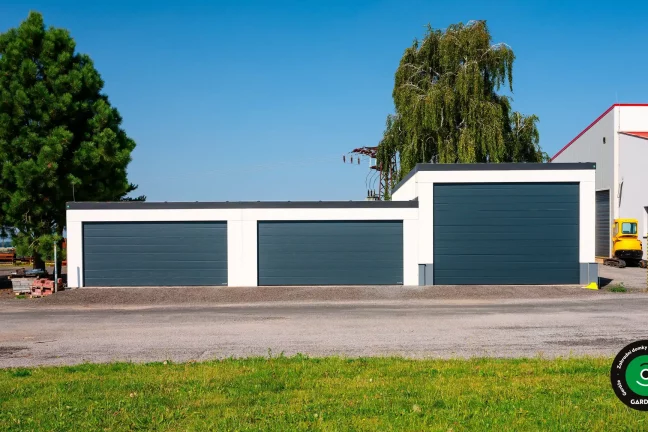 Garážová stavba s více velkými vstupy na stroje a auta.