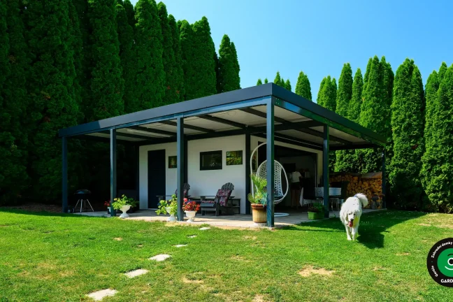 Zahradní domek s garážovými vraty a přístřeškem na sezení.