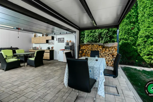 Moderní domeček s pultovou střechou a letní kuchyňkou uvnitř.