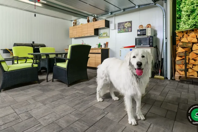 Zahradní domek s moderními garážovými vraty a kuchyňkou.