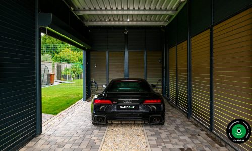 Zadní pohled na auto v moderním přístřešku s lamelami.