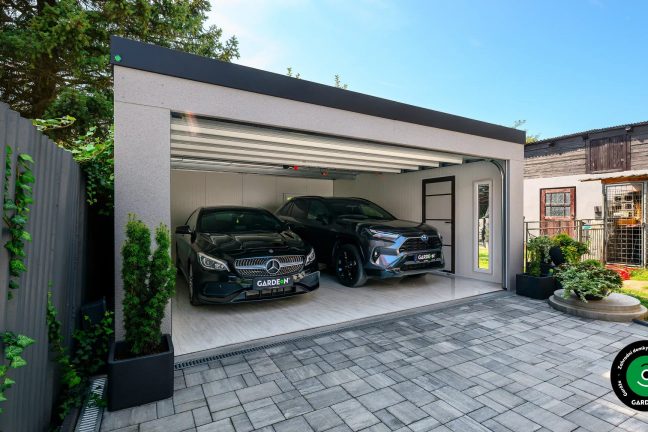 Dvojgaráž s otevřenou bránou a dvěma vozidly.