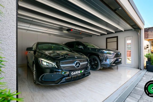 Interiér garáže se dvěma auty a světlou podlahou.