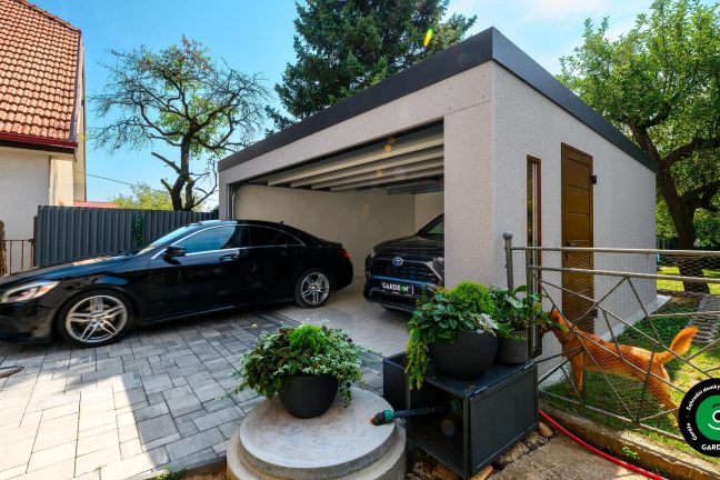 Auto vychází z moderní garáže na vydlážděný dvůr.