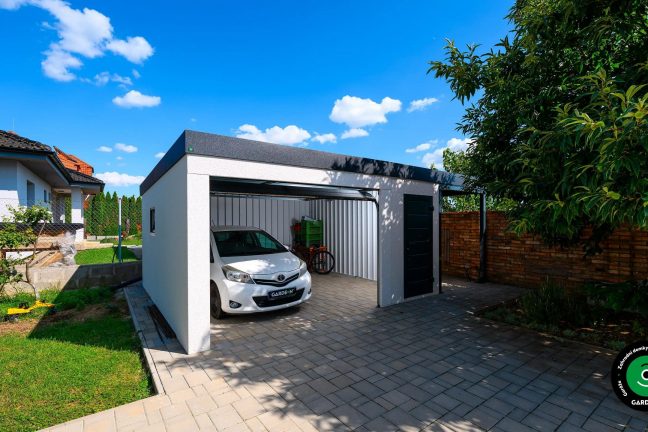 Moderní montovaná garáž s pultovou střechou a parkovaným bílým autem Toyota.