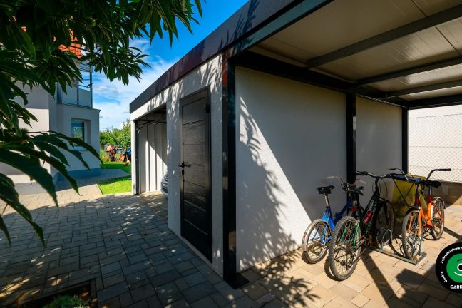 Garáž s přístřeškem pro kola a moderním designem s antracitovými doplňky.