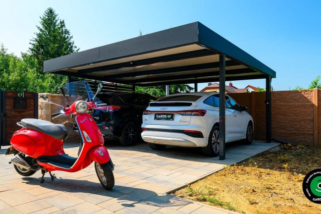 Černý přístřešek pro dvě auta s kontrastní cihlovou stěnou a oplocením.