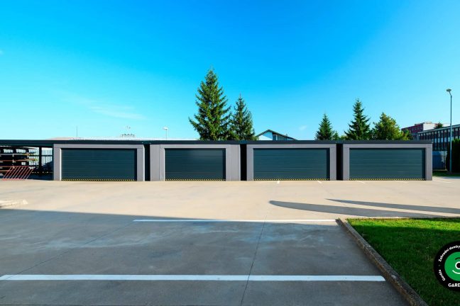 Řadové garáže s moderním designem a tmavě šedými vraty.