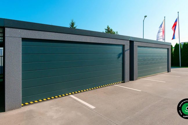 Detail garážových vrat s ochranným pásem při vjezdu.