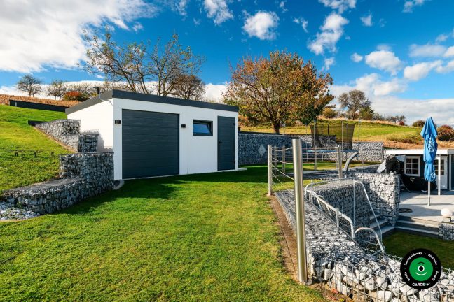 Moderní garáž u bazénové části s gabionovým opevněním okolí