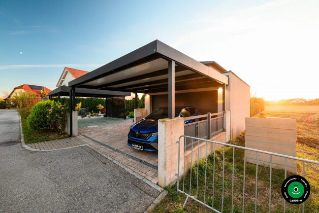 Prostorná garáž s přístřeškem dlažbou a výhledem na upravenou zahradu