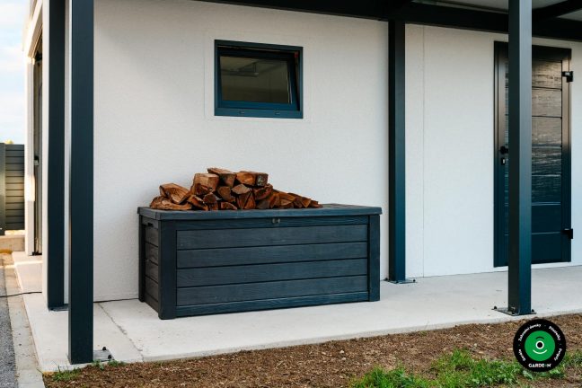 Dřevěný box s uloženým dřevem pod přístřeškem