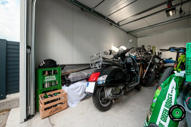 Interiér garáže s motorkami a úložnými přepravkami