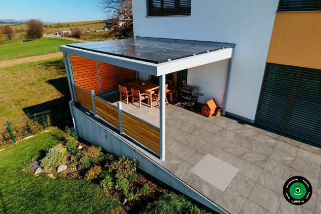 Zastřešená pergola s terasovým nábytkem u rodinného domu