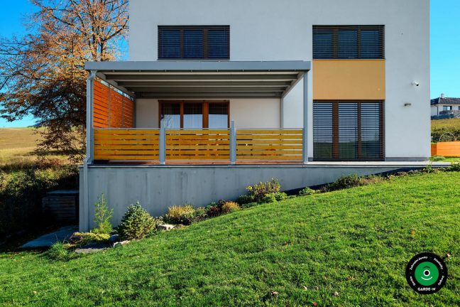 Pergola poskytující stín nad posezením na domovní terase