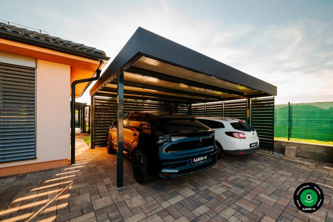 Zastřešený přístřešek u domu se dvěma zaparkovanými auty