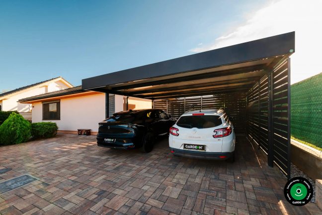 Přístřešek s černým a bílým autem chráněnými pod pevnou střechou