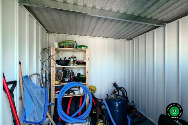 Vnitřek malého domku s uloženým sezónním zahradním vybavením